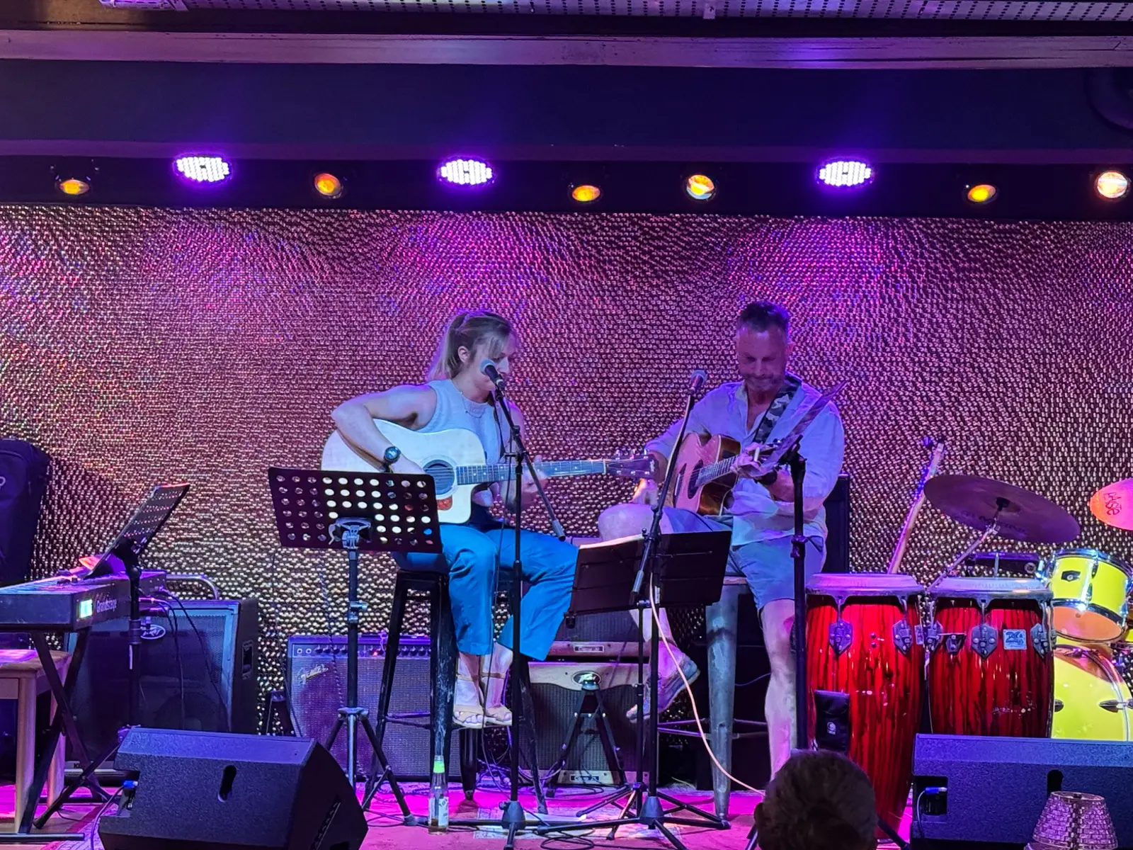 Will and Steph performing in Singapore beside two red drums