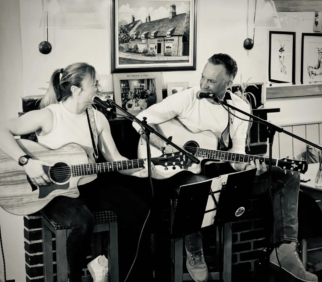 Will and Steph playing acoustic guitars in front of a fireplace